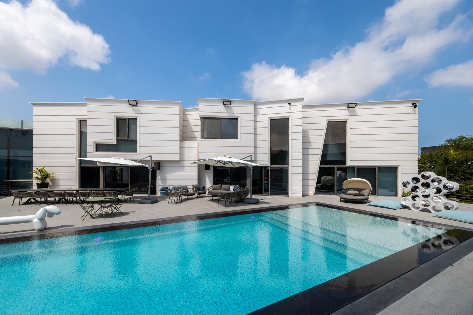 Modern white house across a long pool